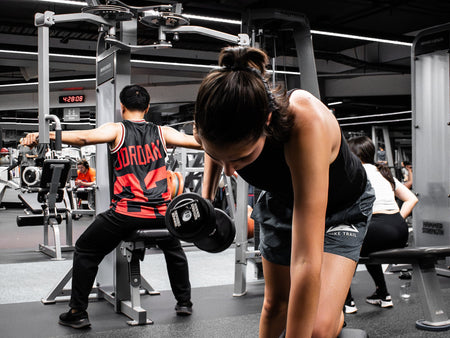 Female student performing a single arm dumbbell row exercise in the RMIT Active Hub