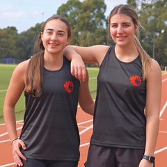 Two female models standing front view on running tracks wearing black RMIT Redbacks Singlets with red and black Redbacks logos on left chests, the model on the left resting her right arm on the right model’s shoulder, both smiling, subtle light black horizontal patterns visible on singlets. Available at the RMIT Store.
