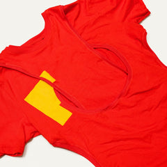 Tangled fashion-student designed upcycled tee from RMIT Store, featuring a red upcycled short-sleeve tee with reconstructed gathered and curved seam lines, bright yellow rectangular appliqués and dark contrasting panels near the lower hem, shown in a close-up showing reconstructed seams, appliqué, panel work and surface details on a light studio background.