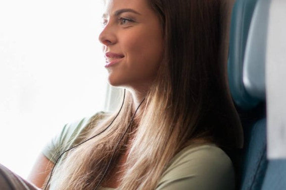 Woman sitting in a Singapore Airlines plane, relaxed and comfortable.