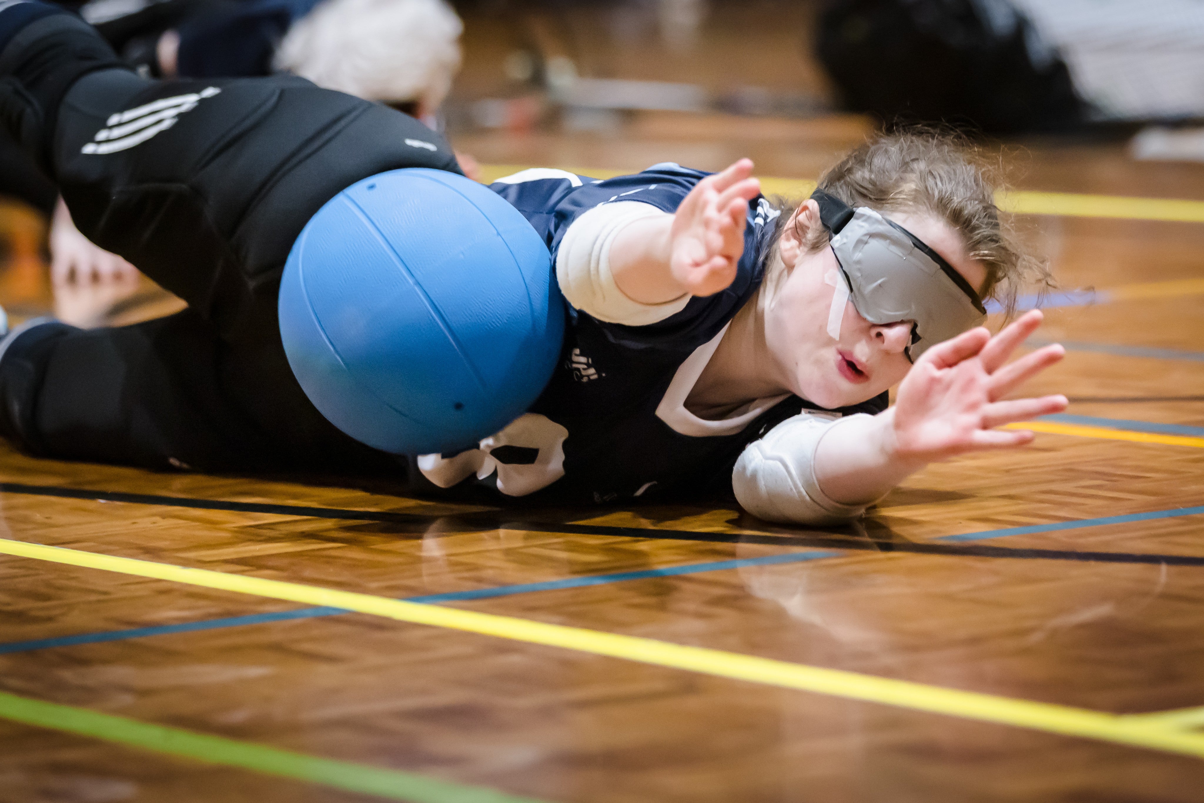 goalball competitor diving to block a ball during a match