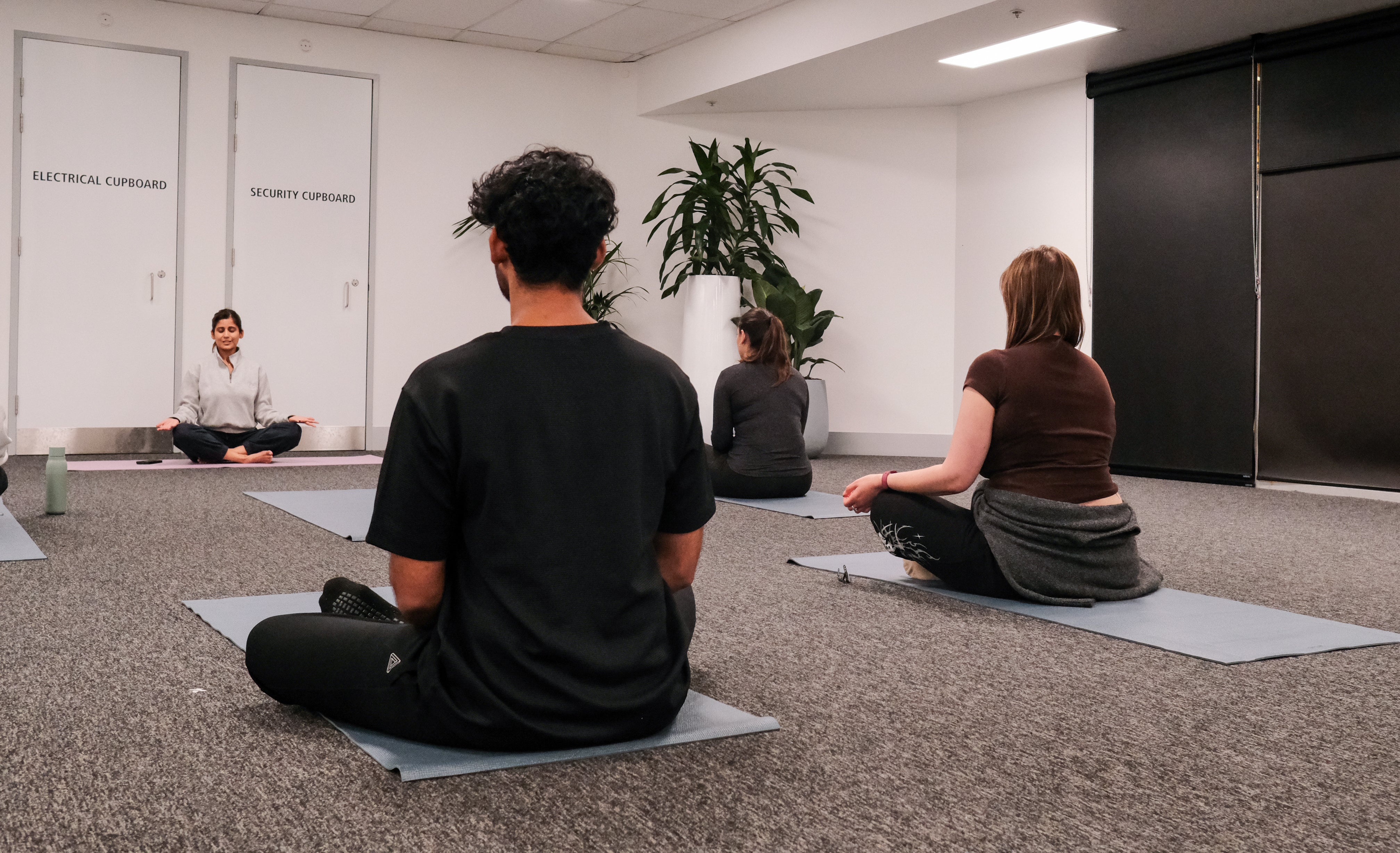 participants and instructor performing a seated yoga pose