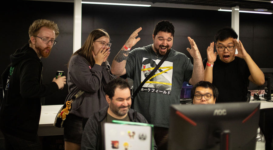 Group of people reacting excitedly in a room with gaming equipment at the RMIT Games Hub