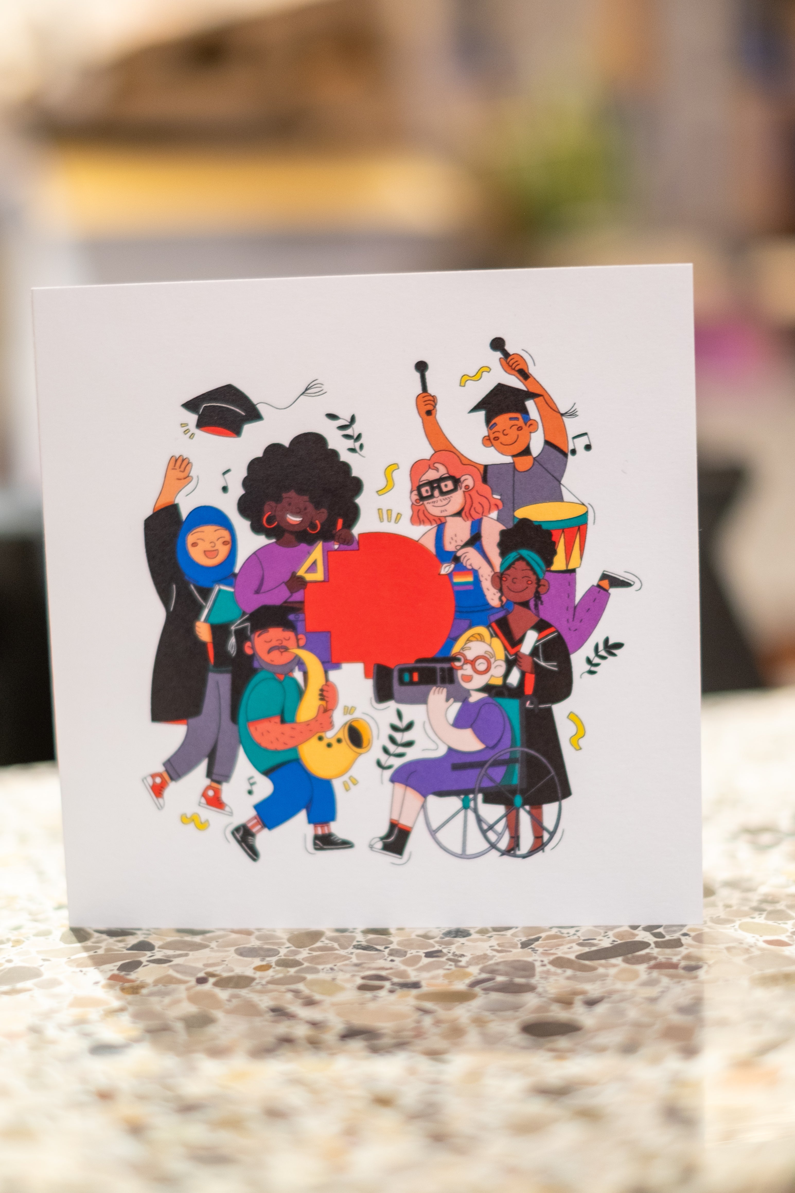 Close-up view of the alumni-themed pattern printed on the right side outside the RMIT Alumni graduation card, showing various alumni-related icons on a white background, available at the RMIT Store.