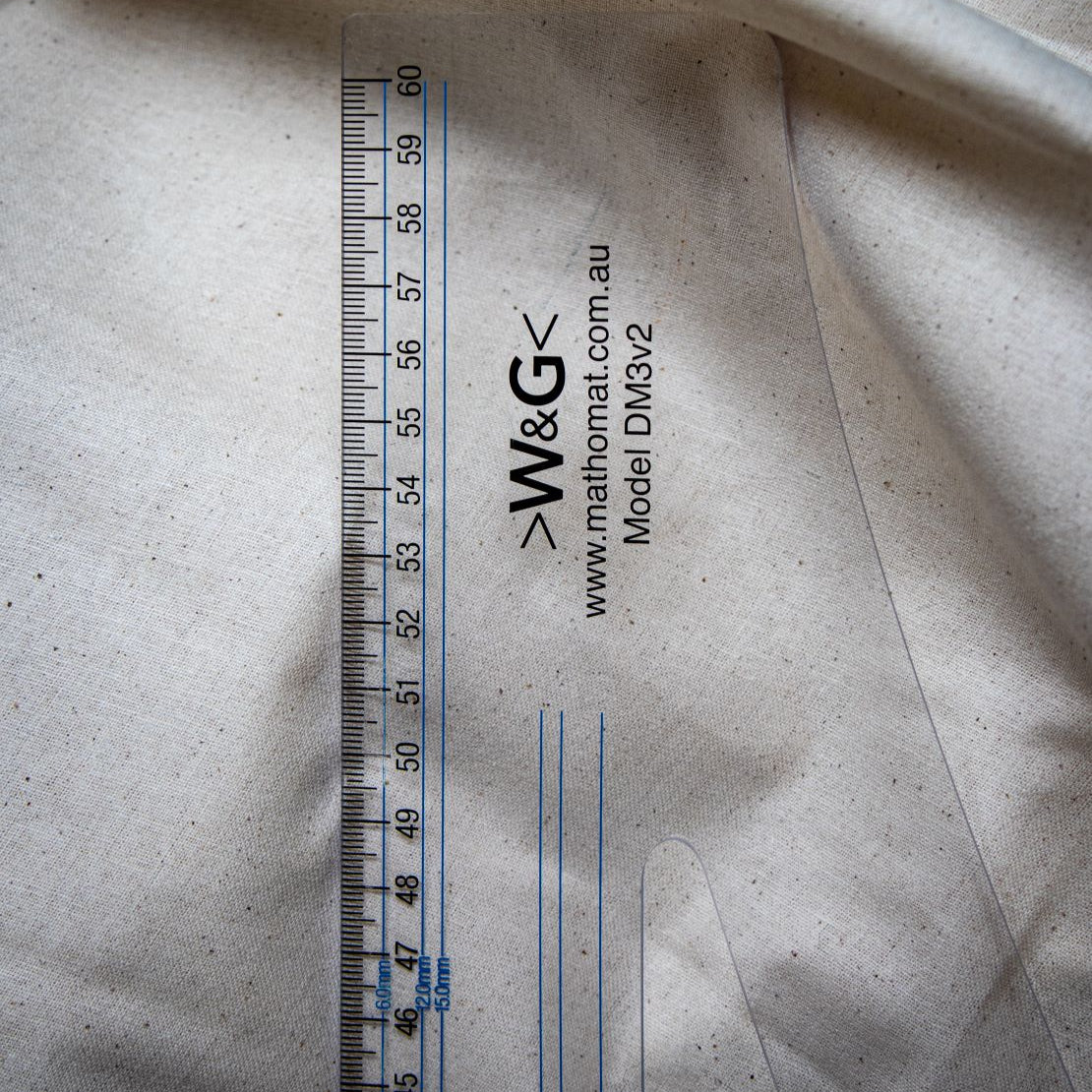 Detailed view of DM3 Graduated Set Square Ruler branding and model number DM3V2 from RMIT Store, with metric markings on a beige background.
