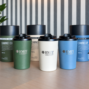 RMIT Everyday Reusable Cups in Khaki, Oat and River, featuring matte finishes, black flip-top lids and metallic RMIT University logos, displayed front-on with matching Camino Cup packaging on a light timber table at RMIT Store.