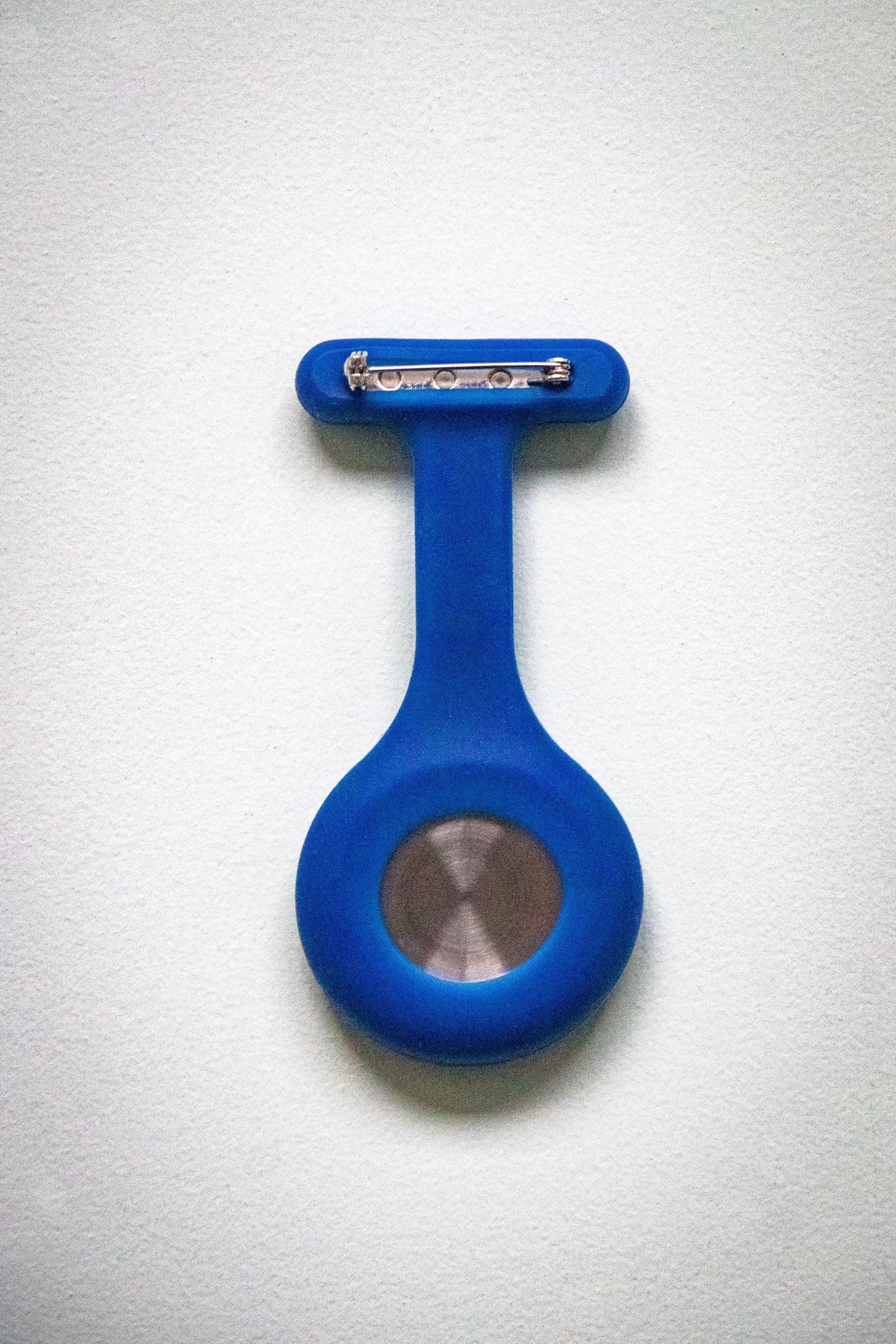 Rear view of the RMIT Store navy fob watch, showcasing the silver metal pin clasp and smooth silicone backing. The navy silicone contrasts with the stainless steel clip, photographed against a white background.