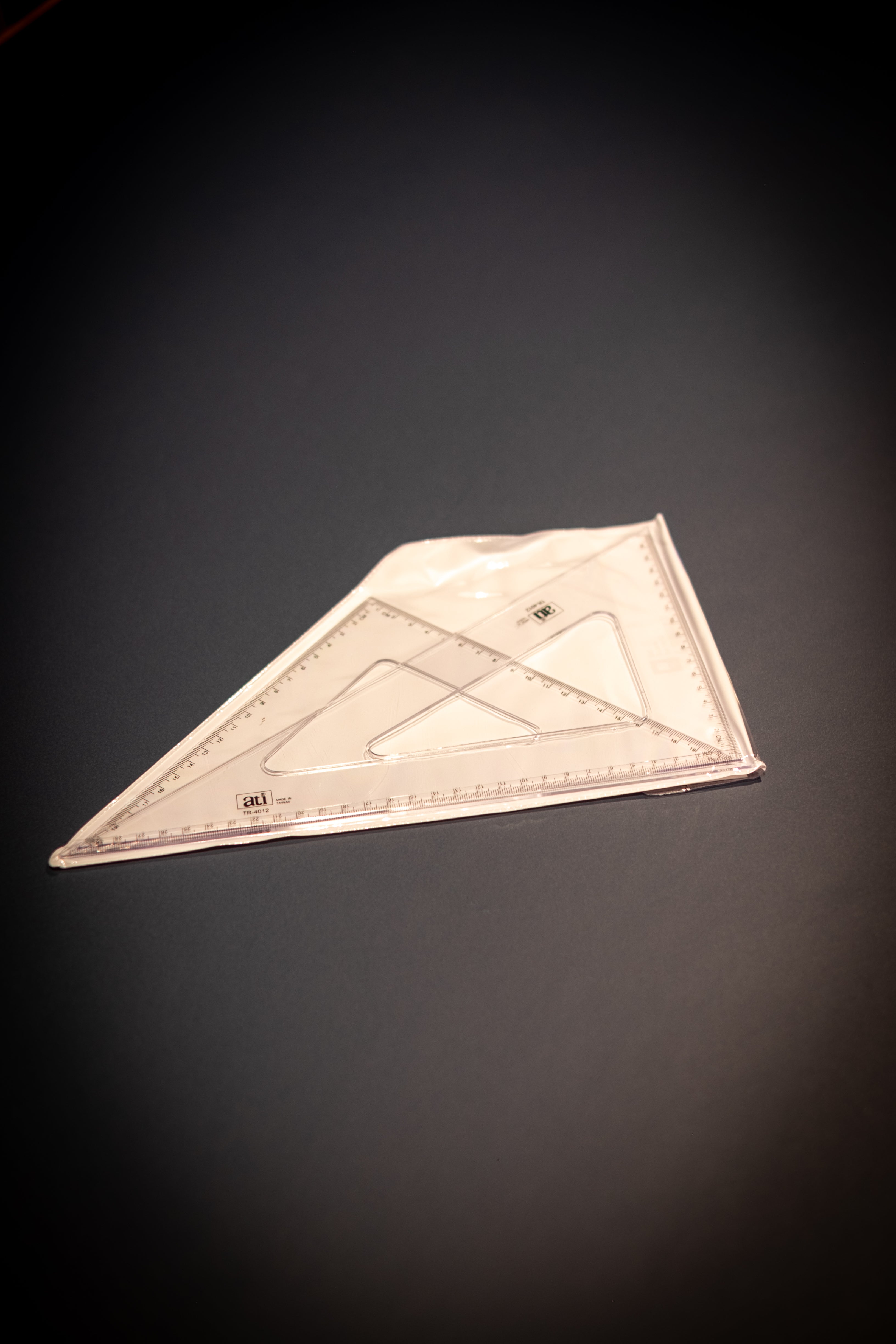 Interior Design and Decoration Kit featuring a transparent plastic triangular ruler set inside a clear zip pouch at RMIT Store, showing two overlapping set squares with printed angle guides, centimeter markings.