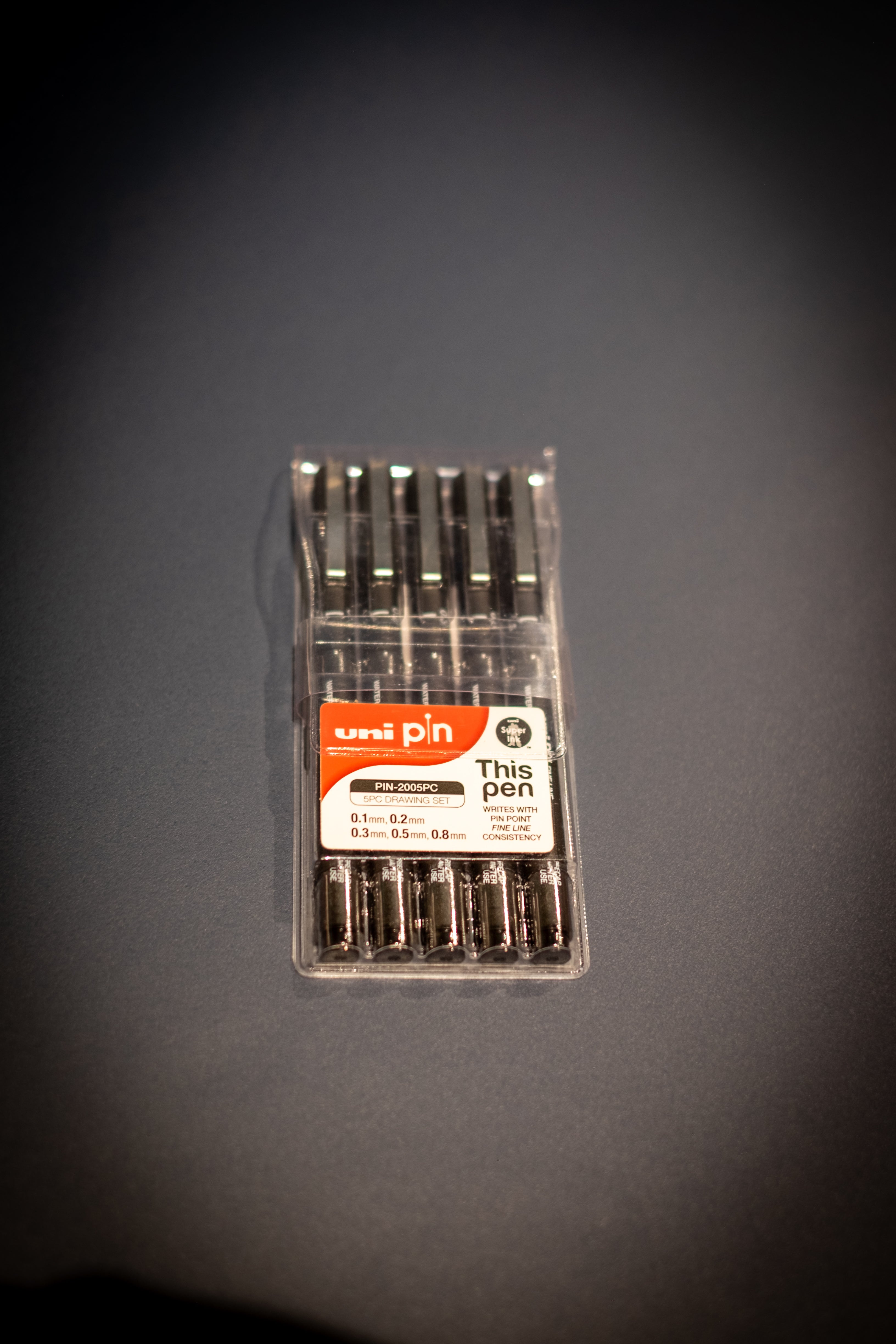 Interior Design and Decoration Kit featuring a Uni Pin 5-piece black fineliner drawing pen set in clear plastic packaging at RMIT Store, showing assorted tip sizes labelled 0.1mm, 0.2mm, 0.3mm, 0.5mm, and 0.8mm, with visible “uni pin” branding, precision drawing text, and neatly aligned pens inside the case.