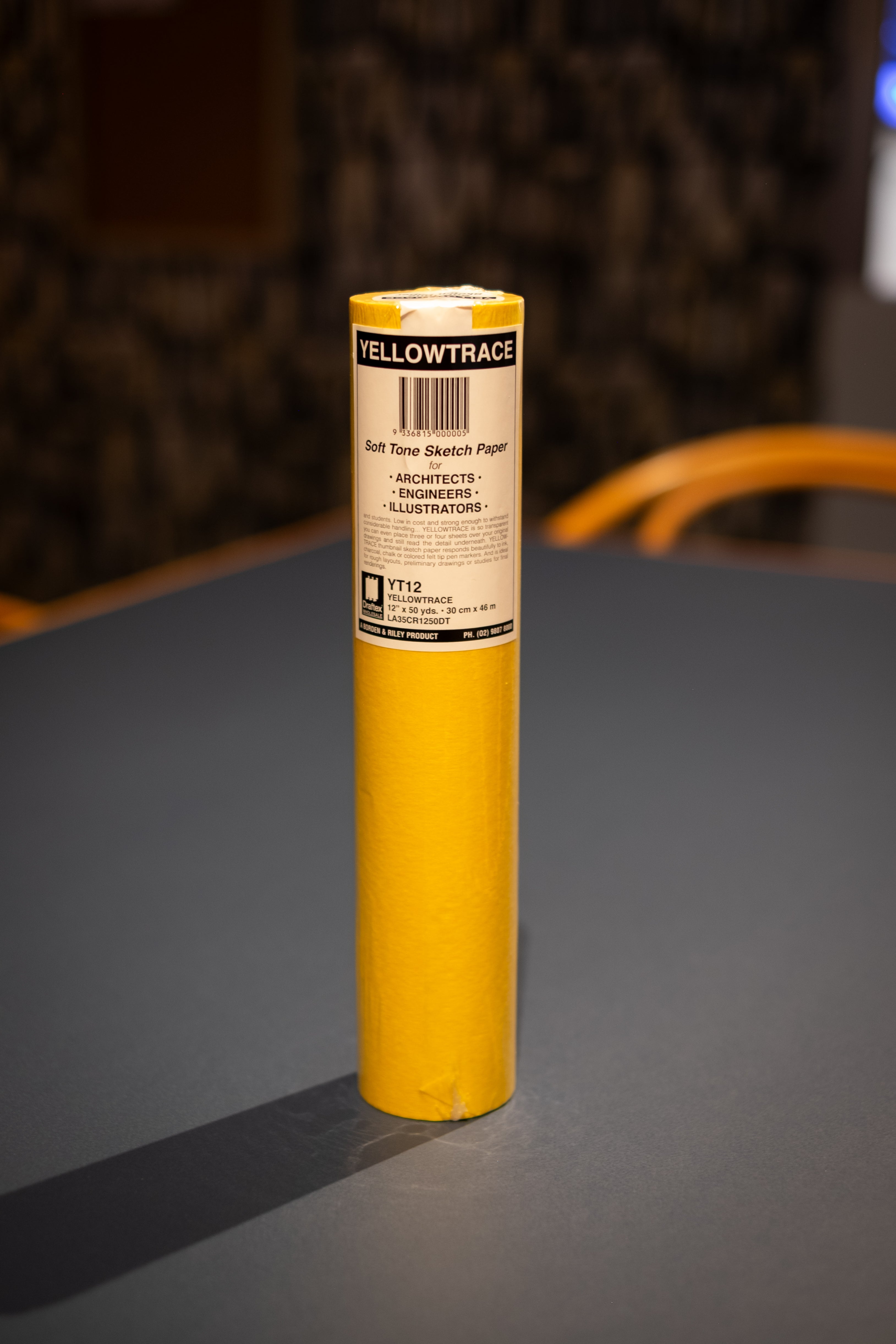 Interior Design and Decoration Kit featuring a rolled Yellowtrace soft tone sketch paper in bright yellow packaging, standing upright on a dark tabletop at RMIT Store, with visible “YELLOWTRACE” branding, barcode label, architects and illustrators usage text, and sealed plastic wrap on the top edge.