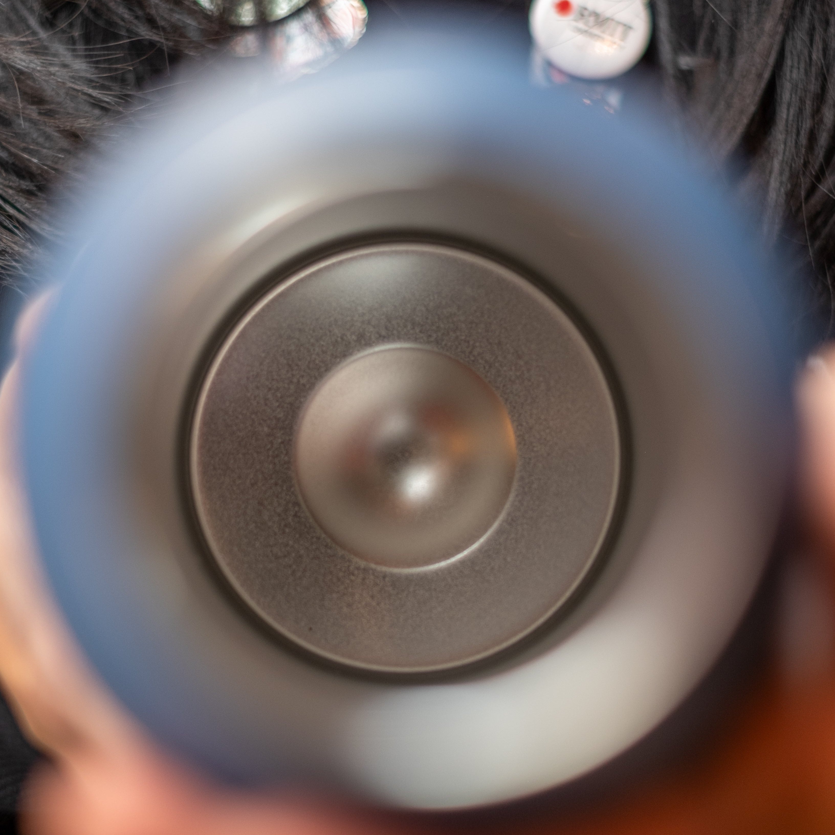Person holding an RMIT University Limited Edition stainless steel water bottle in Petrol Blue, showcasing the smooth, insulated interior with a circular metal base. The wide-mouth opening ensures easy cleaning and temperature retention