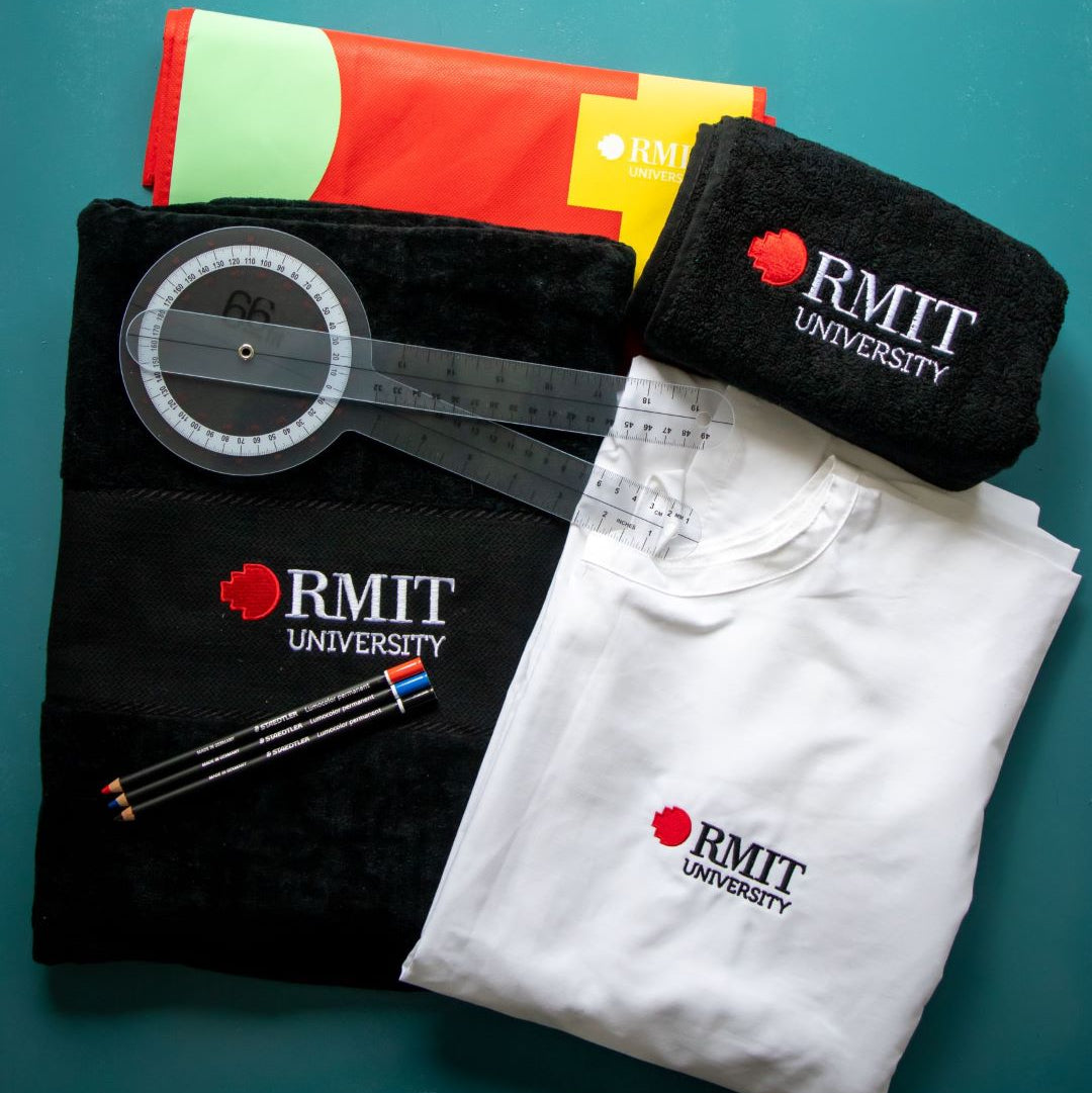 Linen Kit from the RMIT Store including RMIT beach towel, hand towel, medical lab gown, goniometer, Glasochrom markers, and recycle bag, arranged neatly against a teal background to demonstrate their collective utility and branding.