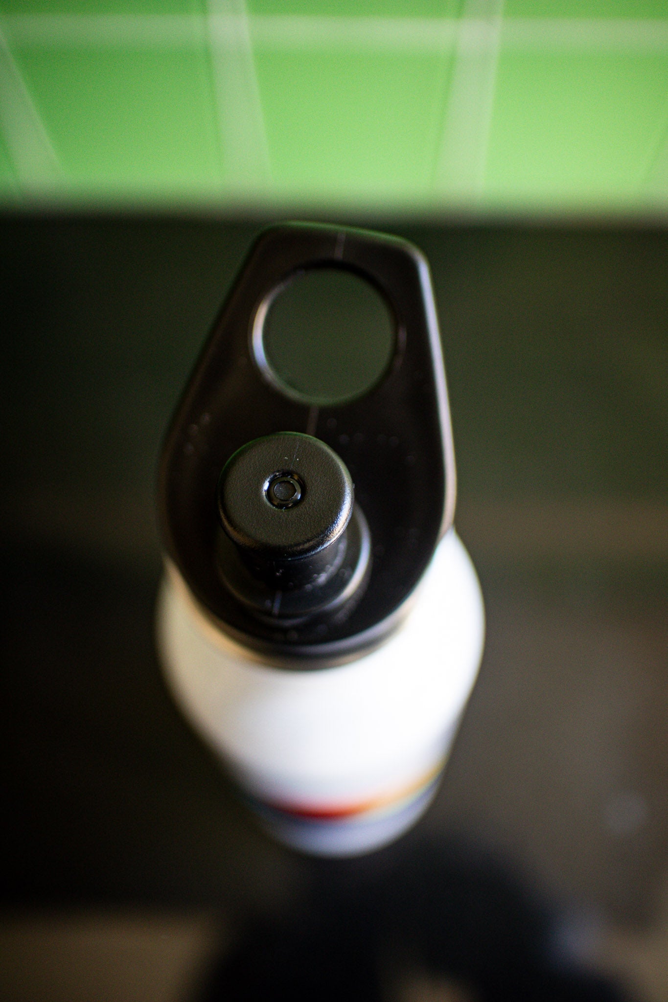 Top view of the Progress Pride bottle showing its matte white body and black screw cap, with only the top section visible. Available at the RMIT Store.