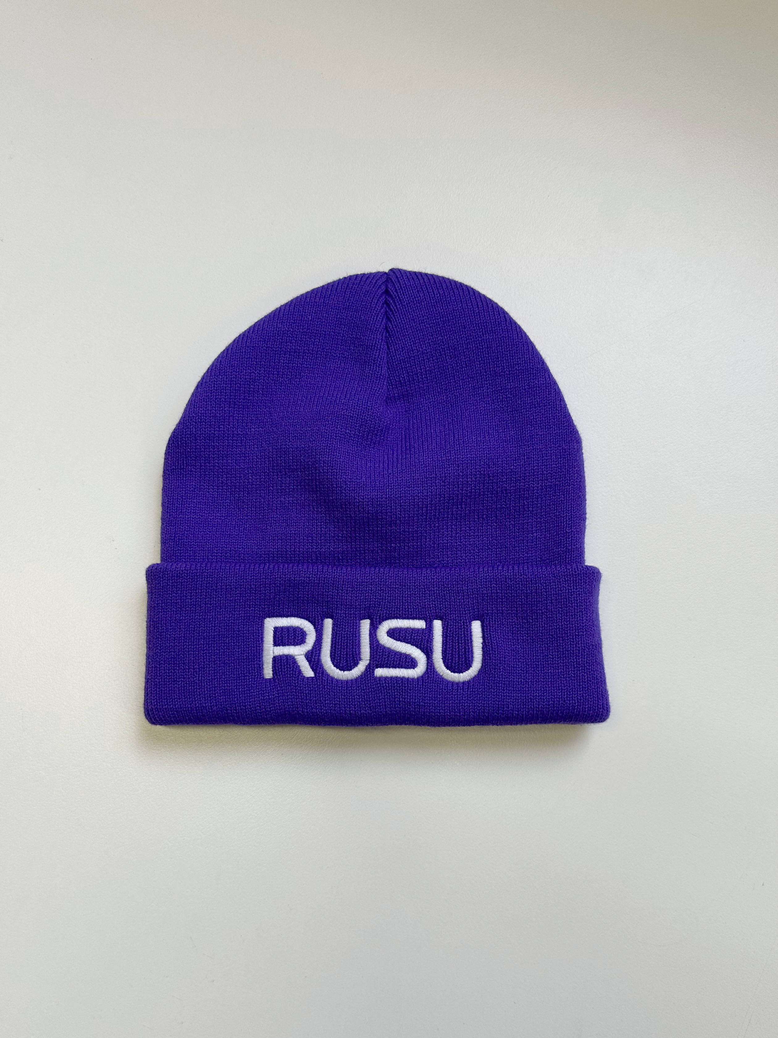 Purple RUSU Beanie with white embroidered 'RUSU' logo on the front, featured in the RMIT Store. Made of soft, warm knit material.