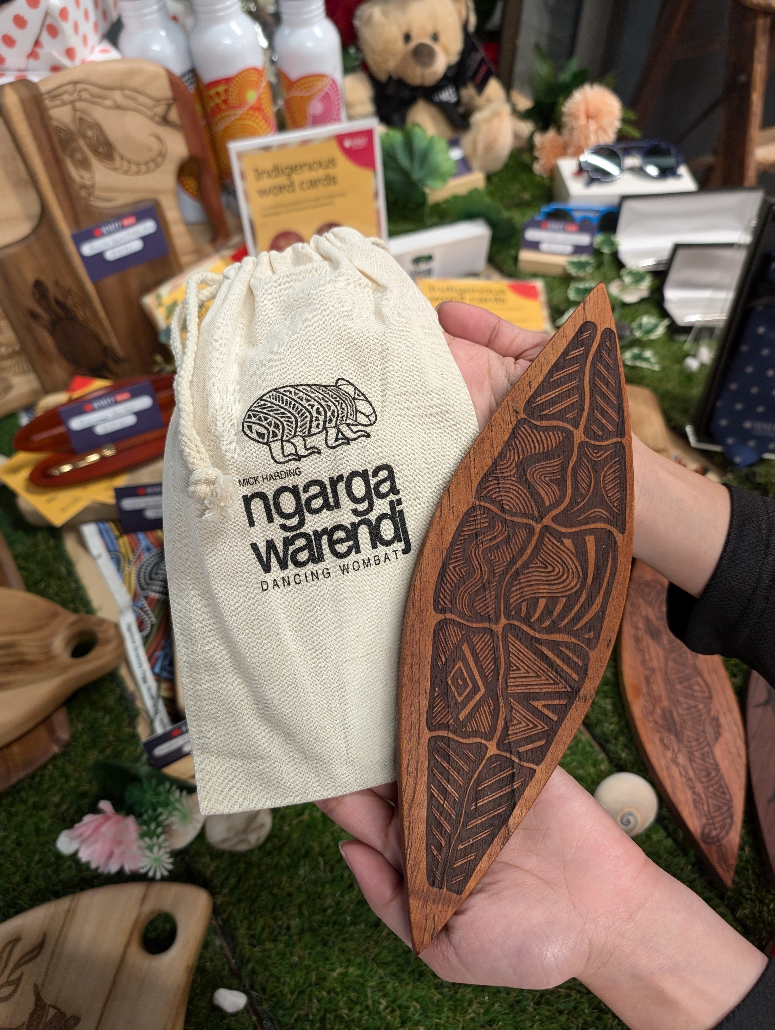 Ngarga Warendj Indigenous Australian Gugra the Possum Skin Cloak designed engraved Red Cedar Malgarr(shield) with RMIT Branding. Possum Skin engraved design shown from front held by model.