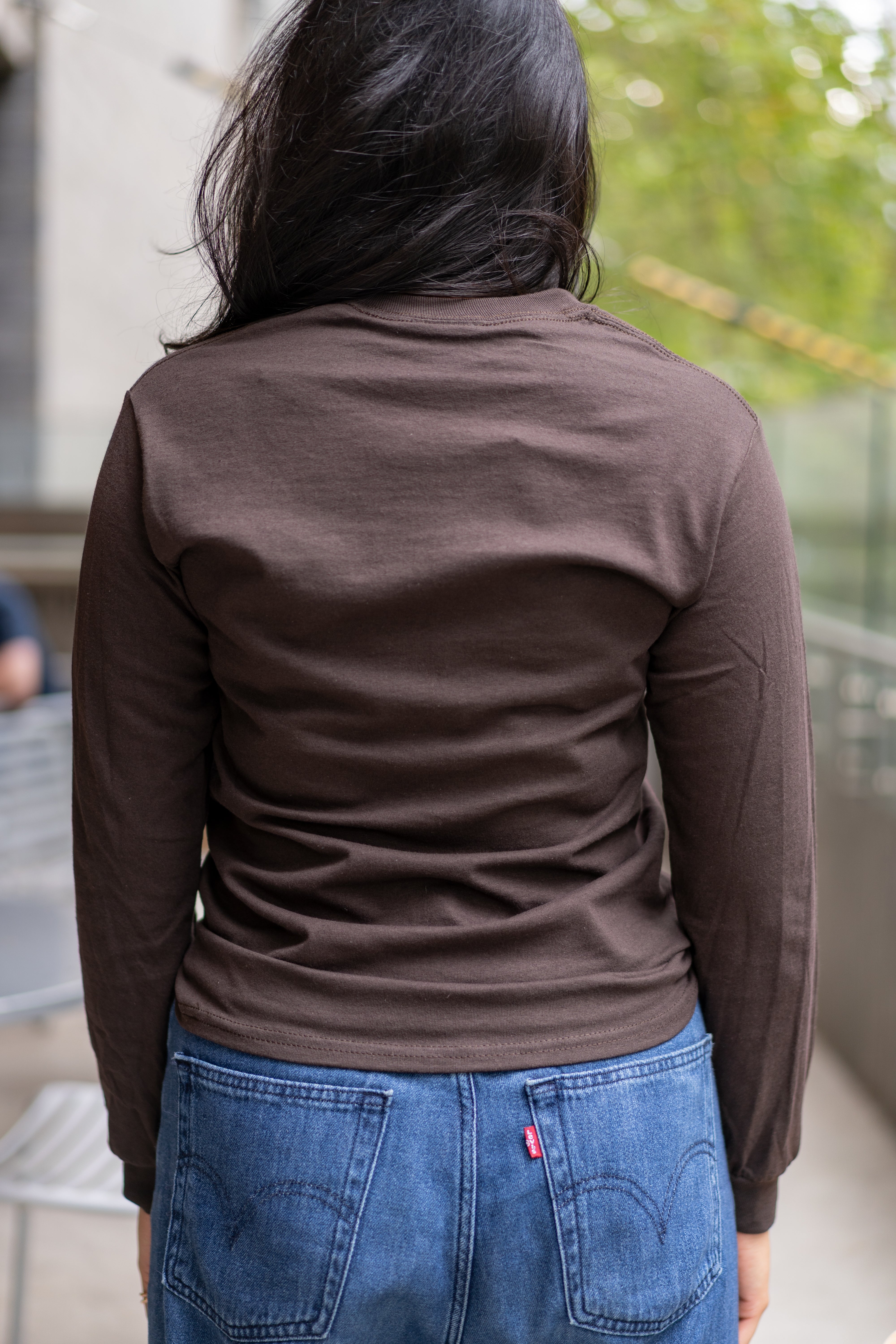Back view of student wearing RMIT Dawson long sleeve tee in chocolate brown on campus.