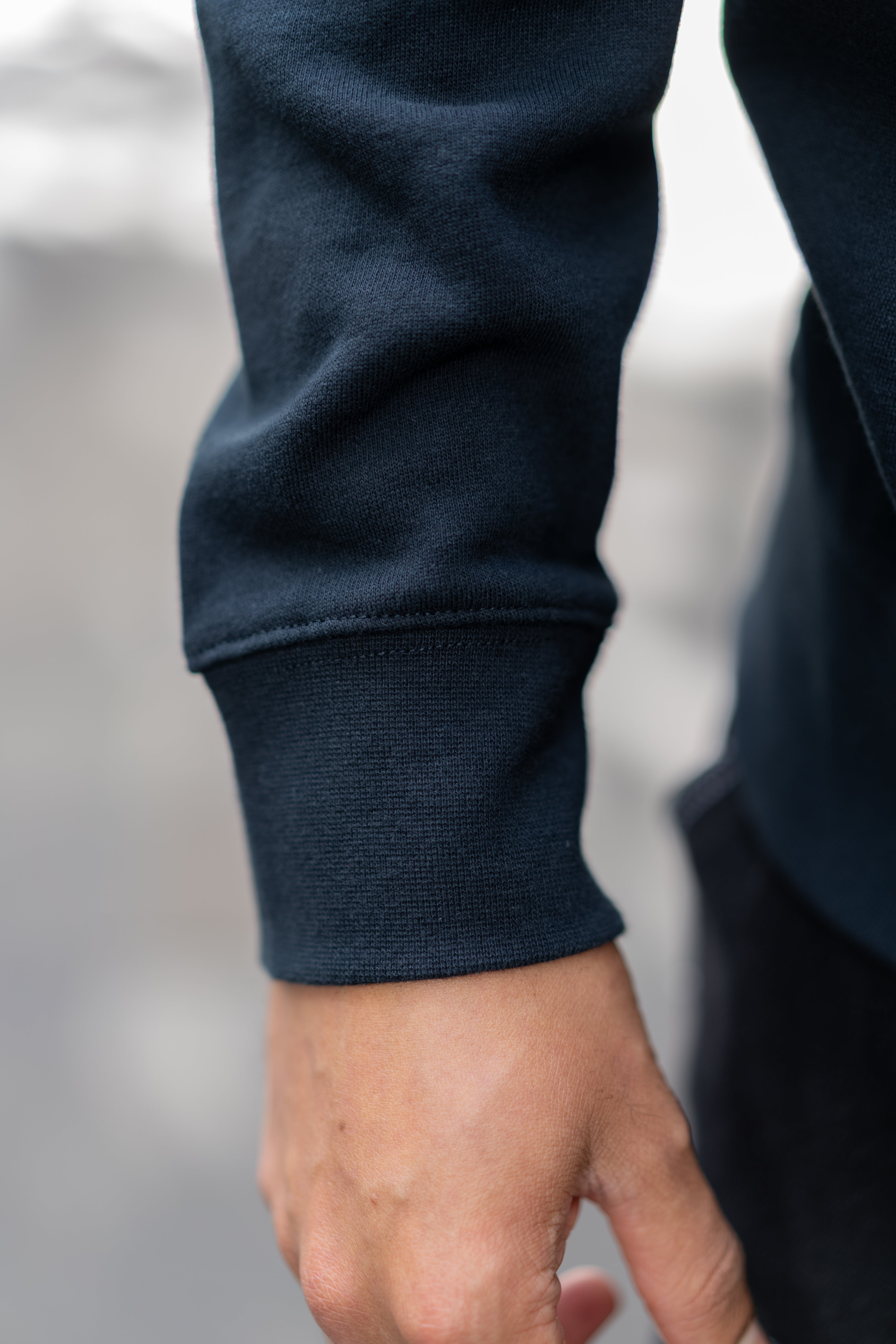 Close-up of sleeve cuff detail on RMIT Essential half zip jumper in navy.