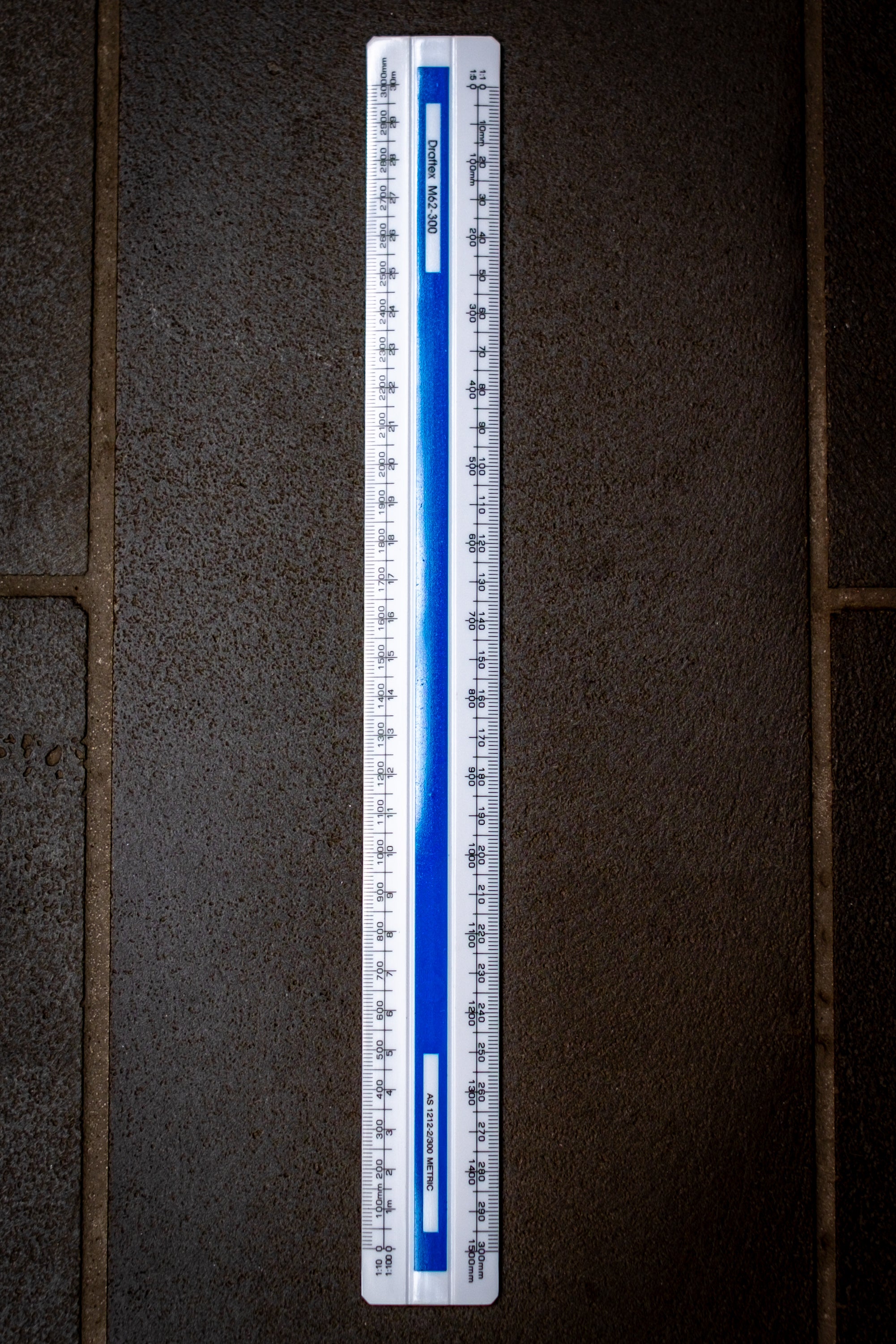 Top-down view of the Scale Ruler M62 from the RMIT Store, displaying metric measurements in clear detail on a textured surface.